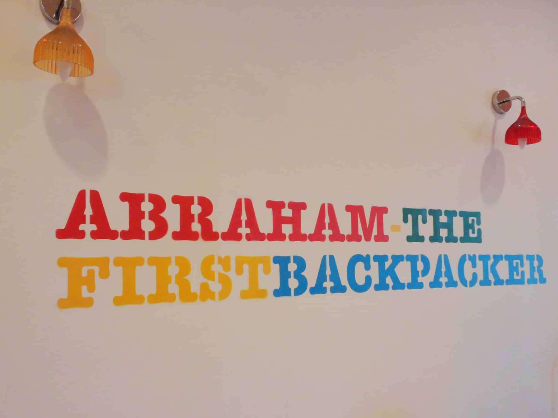 Phrase "Abraham the First Backpacker" across a hostel entryway wall
