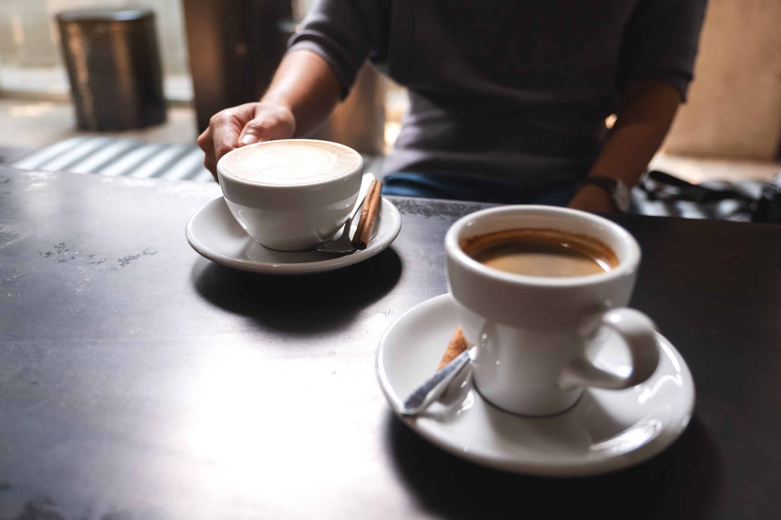Closeup of a woman at a table with two cups of coffee
