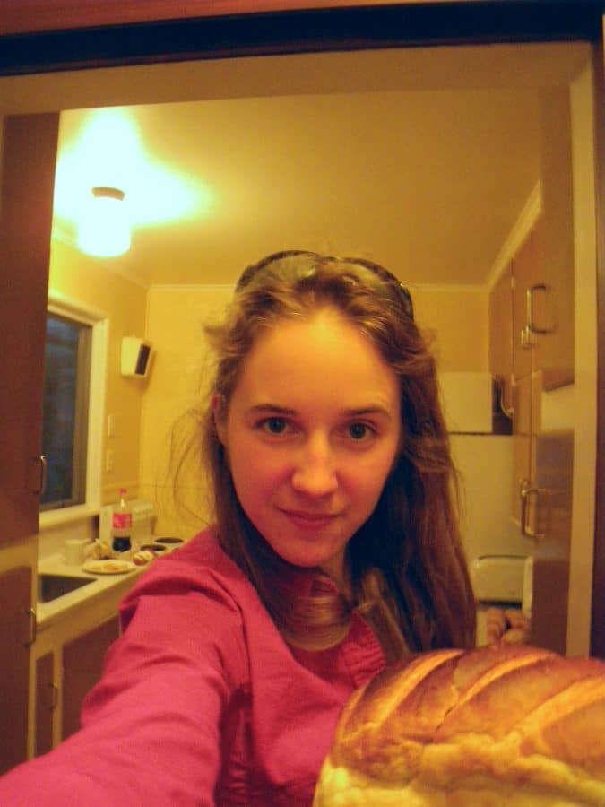 Hicks, Hoodlums, & Highrises author, Nicole Braun in a selfie with a loaf of bread