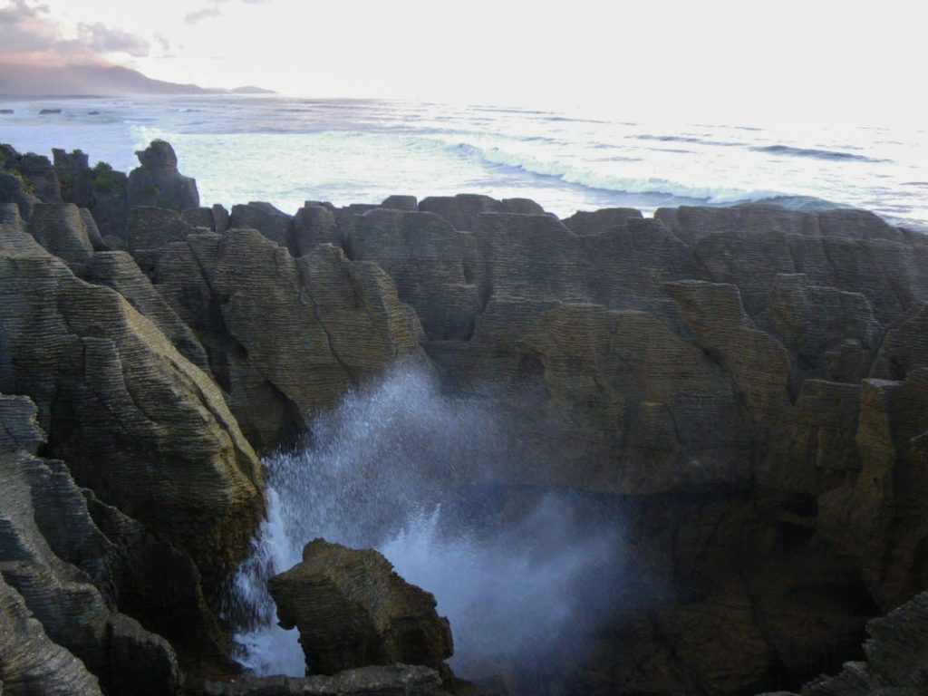 Water begins busrting through a blowhole the pancake rocks of New Zealand's west coast