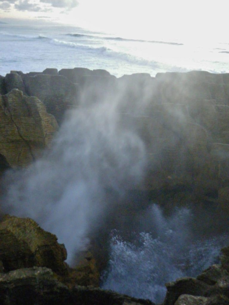 Water bursts through a blowhole the pancake rocks of New Zealand's west coast