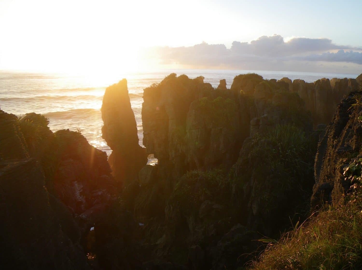 The sun sets behind the pancake rocks of New Zealand's west coast